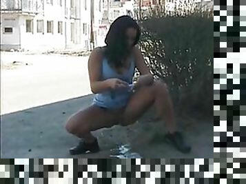 Babe takes big piss on a public street