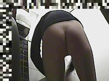 Curly blonde with skinny body is pissing in the toilet