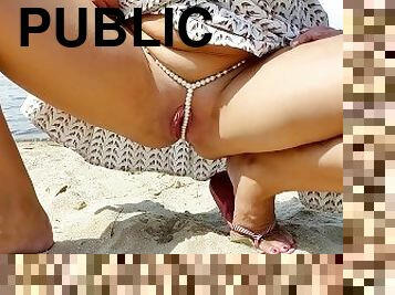 Alice in sexy thin panties pees through them on a public beach on the sand. pussy close up