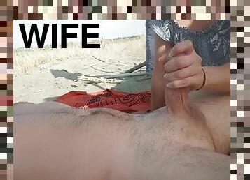 My wife jerks off my cock in front of a stranger on a nude beach