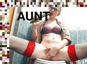 Aunt in fishnets uses a cucumber on herself