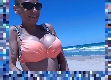 Tattooed MILF gives head on the public beach