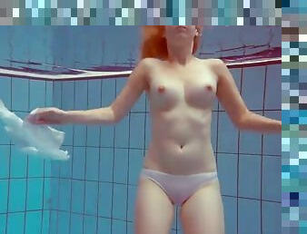 Cute redhead playing naked underwater