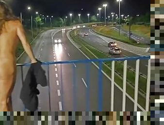 Crazy MILF totally naked over the highway. She was pissed on her clothes.